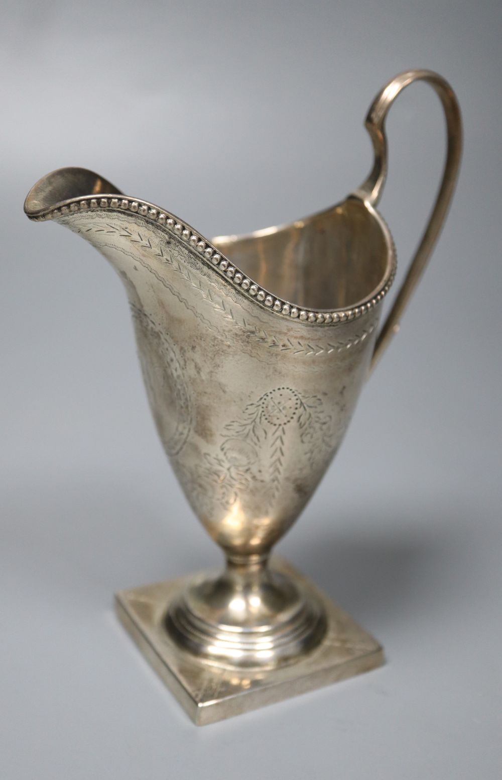 A George III engraved silver helmet shaped cream jug by Hester Bateman, London, 1785, 14.9cm, 4.5oz,